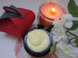 cream next to a candle and flowers